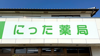 にった薬局の看板