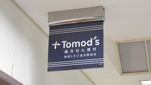 薬局トモズ 金沢駅前店の看板