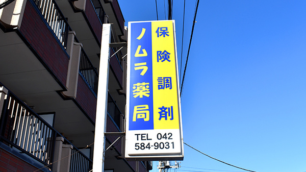 ノムラ薬局　多摩平店（第五小学校前）の看板